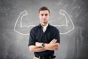 Homme bras croisé devant un tableau noir où des bras musclés sont dessinés - Pourquoi Gmax est un aphrodisiaque masculin efficace - ShytoBuy France Homme bras croisé devant un tableau noir où des bras musclés sont dessinés - Pourquoi Gmax est un aphrodisiaque masculin efficace - ShytoBuy France