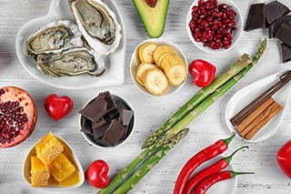 Photo de chocolat, huîtres, piment, babane, asperges et grenade - Image de l'article Conseils pour s'éclater au lit et s'amuser lors du rapport sexuel - Rubrique Lutter contre une baisse de la libido des femmes pour retrouver excitation, désir et plaisir - Sous-rubrique Cultiver son désir sexuel avec des aliments aphrodisiaques